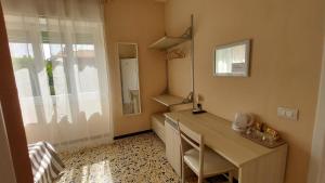 um escritório com uma secretária e uma janela em La terrazza del Sole Guest House em Bosa