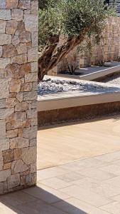 a stone wall with a tree in the background at Casa Costa Suites in Kanali
