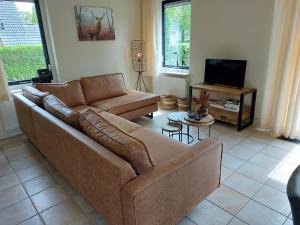 - un salon avec un canapé et une télévision dans l'établissement Vakantiehuis Kiki, à Sondel