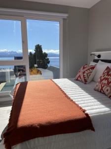 um quarto com uma cama e uma grande janela em Acqua Apartments Bariloche em San Carlos de Bariloche