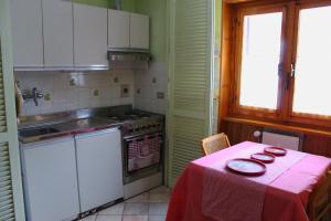 uma cozinha com uma mesa com uma toalha de mesa vermelha em Fiocco di neve, residence Magnola em Ovindoli