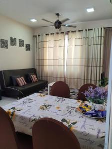 a living room with a table and a couch at Leezahomestay in Bayan Lepas