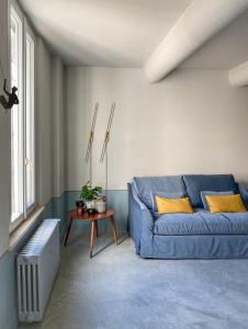 a living room with a blue couch and a table at Maison B in Mantova