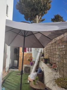 a large white umbrella in a yard with a table at The lonley unit in Nahariyya