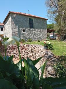 une maison en pierre en face d'un mur en pierre dans l'établissement Casa Bolero, à Ferreira