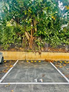 a parking lot with a tree behind a fence at HIGH-END apartment , with a private parking and an elavator in Tel Aviv