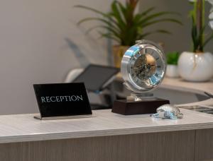 - une réception avec une horloge et un ordinateur portable dans l'établissement Skyline Rooms & Suites, à Grottaminarda