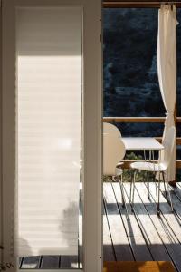 a patio door with a table and chairs on a deck at Nature House with a wooden porch - Pasika, house Luca in Pučišća