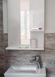 a bathroom with a sink and a mirror and a window at Nature House with a wooden porch - Pasika, house Luca in Pučišća