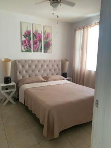 a bedroom with a bed and two paintings on the wall at Apartamento vacacional - disfruta playa y toboganes a 32km de la ciudad in ArraijÃ¡n