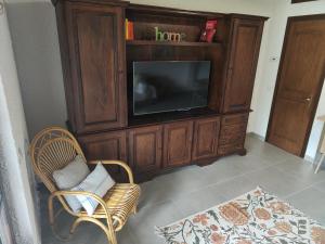 a living room with a entertainment center with a television at Feluca Porto in Porto Valtravaglia