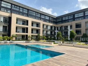 アクラにあるEmbassy Gardensの正面にプールがあるアパート
