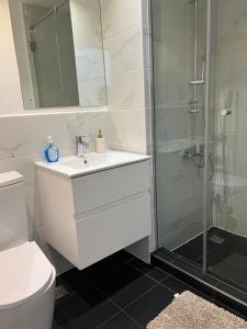 アクラにあるEmbassy Gardensの白い洗面台とシャワー付きのバスルーム +7枚の写真