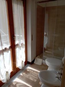 e bagno con servizi igienici, lavandino e doccia. di B&B La Maison a Canicattì