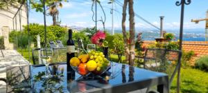 a table with a bowl of fruit and two bottles of wine at Apartments Anamarija in Opatija