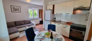 a kitchen and living room with a table and a couch at Apartments Anamarija in Opatija