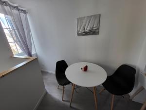 a white table and four chairs in a room at T2 meublé La Souterraine in La Souterraine