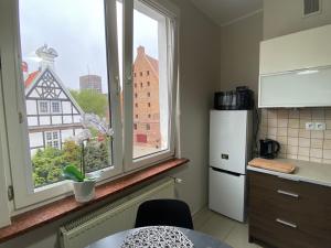 cocina con nevera blanca y 2 ventanas en W Sercu Gdańska, en Gdansk