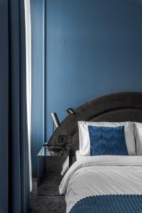 a blue bedroom with a bed and a glass table at Berman House in Kaunas