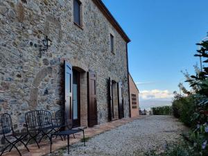 ein Steingebäude mit Stühlen außerhalb des Gebäudes in der Unterkunft Podere del Papa in Viceno + 51 Fotos