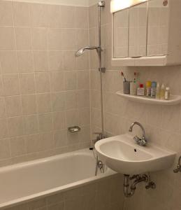 a white bathroom with a sink and a bath tub at Fehmarn-OstseeferienAm Yachthafen 190 in Burgtiefe auf Fehmarn 