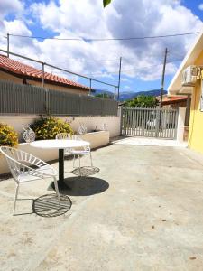 a patio with a table and chairs and a fence at Casa di Athi in Sami