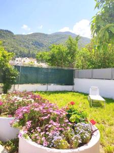 a garden with flowers in a yard with a fence at Casa di Athi in Sami +12 photos