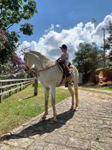 a young boy sitting on a white horse at Casa Amarela in Passa Quatro
