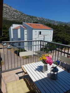 a balcony with a table with flowers on it at Apartment Ruza in Starigrad-Paklenica