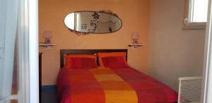een slaapkamer met een bed met een kleurrijke deken bij Casetta Miluna in Ischia