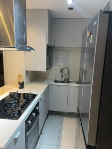 a kitchen with white cabinets and a stove top oven at Branco Haus - Pé na Areia do Caribessa in João Pessoa
