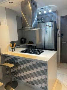 a kitchen with a stove and a counter top at Branco Haus - Pé na Areia do Caribessa in João Pessoa