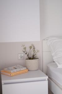 a bedside table with a book and a plant on it at Nature House with a wooden porch - Pasika, house Tonka in Pučišća +25 photos