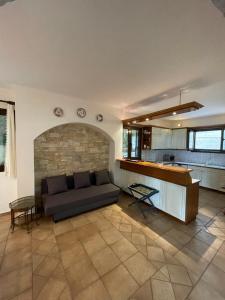 Una sala de estar con un sofá y una cocina. en Villa Sounio, en Sounio