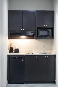 a kitchen with black cabinets and a microwave at Crystal Inn in Baytown