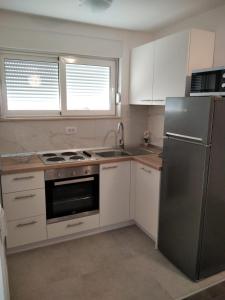 una cucina con armadi bianchi e frigorifero in acciaio inossidabile di Apartment Mateo a Spalato (Split)