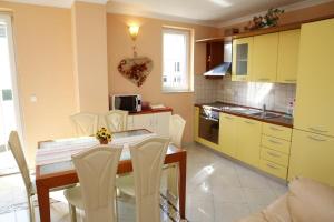 a kitchen with a table and chairs in a kitchen at Vila Nara in Vodice