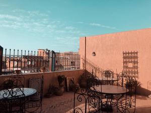 a patio with tables and chairs on a balcony at Dar Pa Labzioui in Meknès