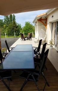 Beychac-et-CaillauにあるGrande maison près de Bordeaux Parking Pétanque WiFiのガラスのテーブルと椅子が備わるパティオ
