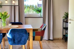 a dining room table with chairs and a window at Ferienhaus CLARNI in Sankt Wendel