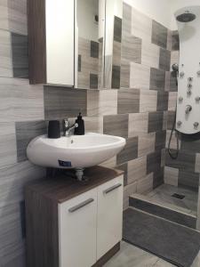 a bathroom with a white sink and a shower at Dorka apartman in Vonyarcvashegy