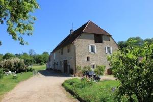 a large brick building with a roof at La Ferme De Montard in Montmorot