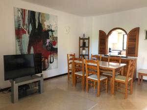 comedor con mesa, sillas y TV en Beautiful Villa with terrace & garden, en Ferragudo