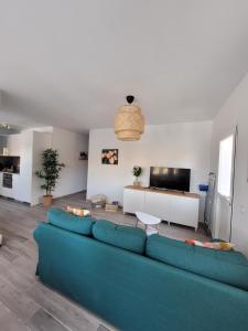 Una sala de estar con un sofá azul y un televisor. en Casa FeLiz, en Tarajalejo