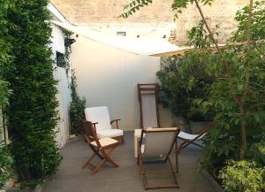 eine Terrasse mit Stühlen, einem Tisch und einem Stuhl in der Unterkunft B&B La Halte Montaigne in Bordeaux