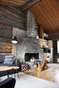 a living room with a stone fireplace at Holiday Home Vonkamies in Luosto