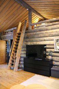 a living room with a fireplace and a wooden wall at Holiday Home Vonkamies in Luosto