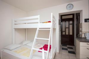 a white bunk bed with a ladder in a room at Luxury Seafront flat Perzagno 3 in Prčanj