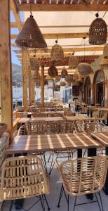 un restaurante con mesas, sillas y luces colgantes en Blue Sky Aparts en Livadia