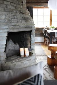 a stone fireplace with two candles in it at Holiday Home Vonkamies in Luosto